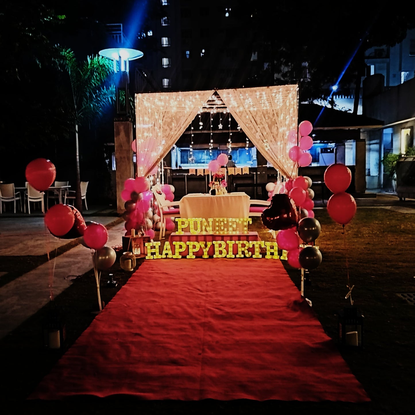 Birthday celebration in Hyderabad featuring a stunning private cabana with helium balloons and floral decor.