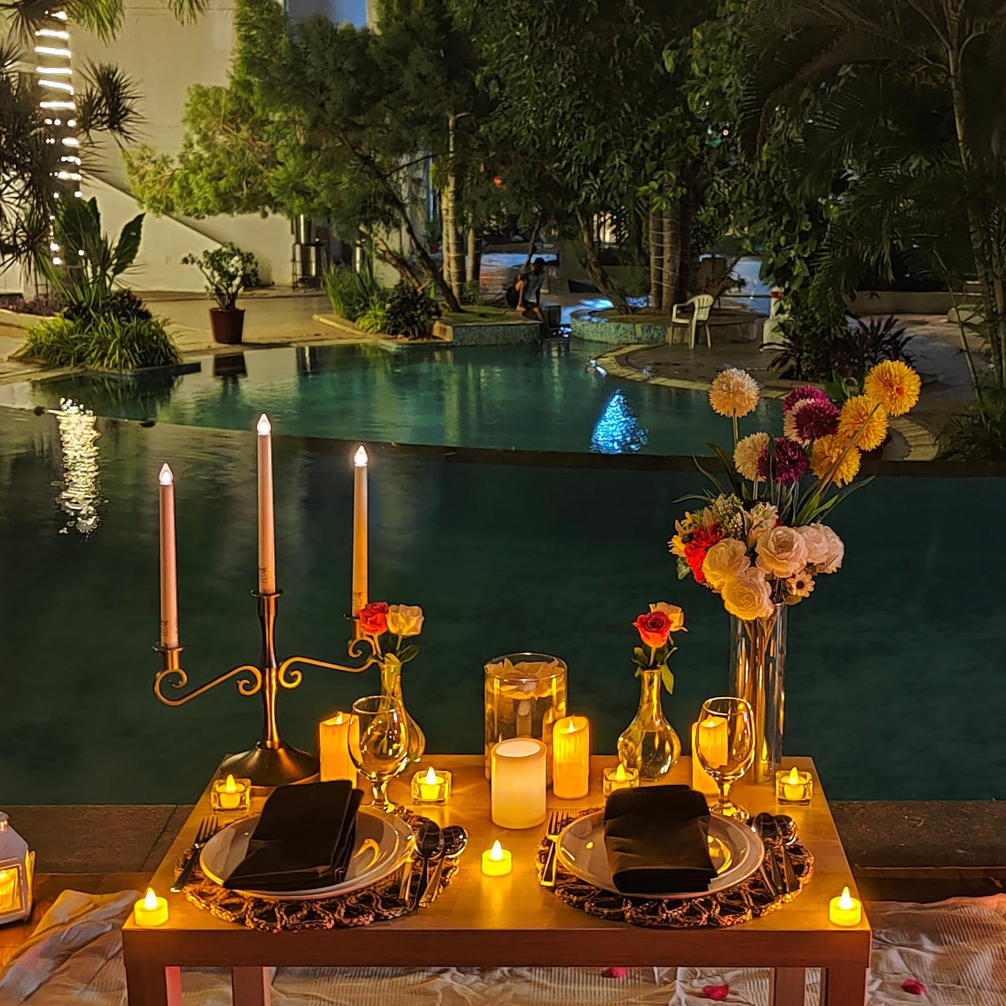 Exclusive birthday celebration in Hyderabad featuring a private poolside dinner with balloons, rose bouquet, and 5-course meal.