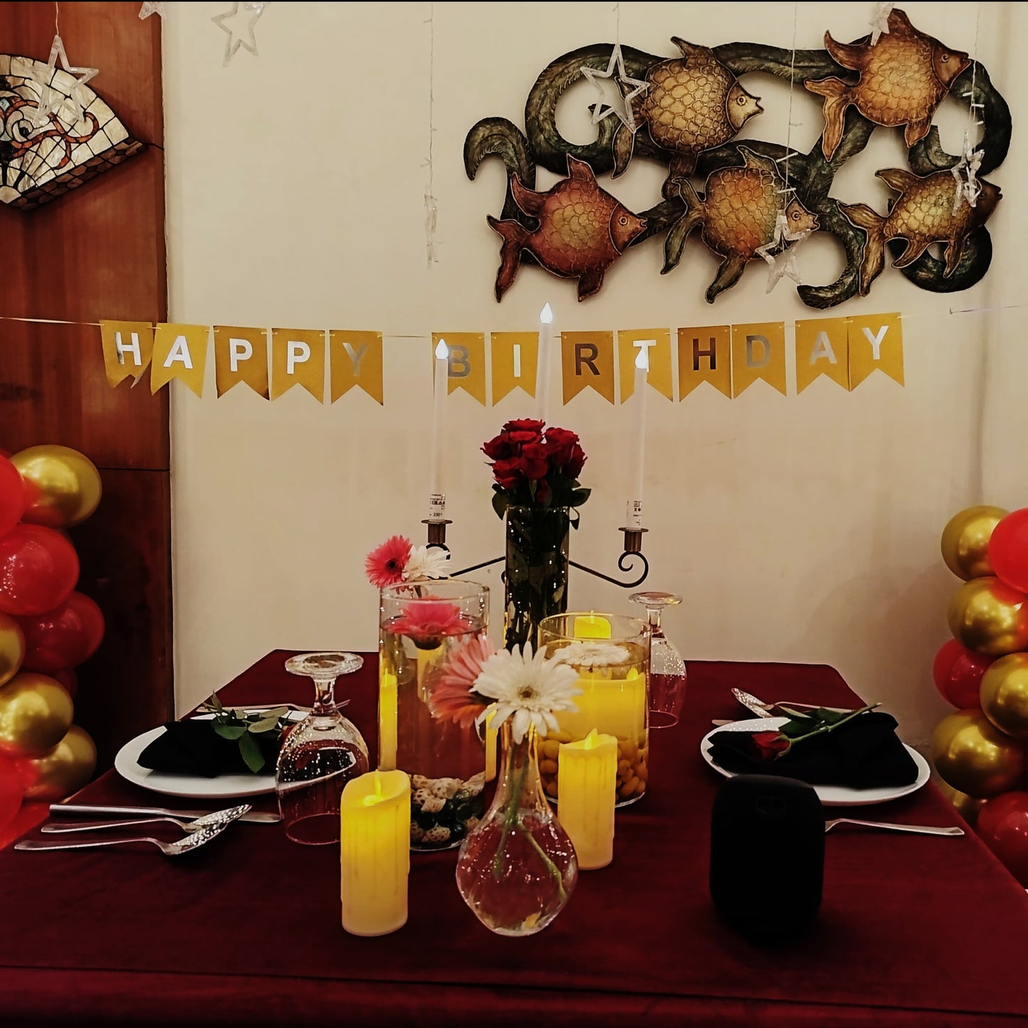 Romantic setup for a birthday celebration in Hyderabad featuring candles, a red carpet entrance, and a 5-course meal.