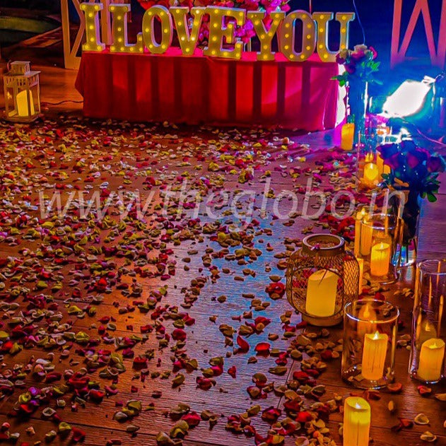 Elegant proposal setup with a private poolside candle light dinner in Hyderabad, featuring candles, flowers, and a 5-course meal.