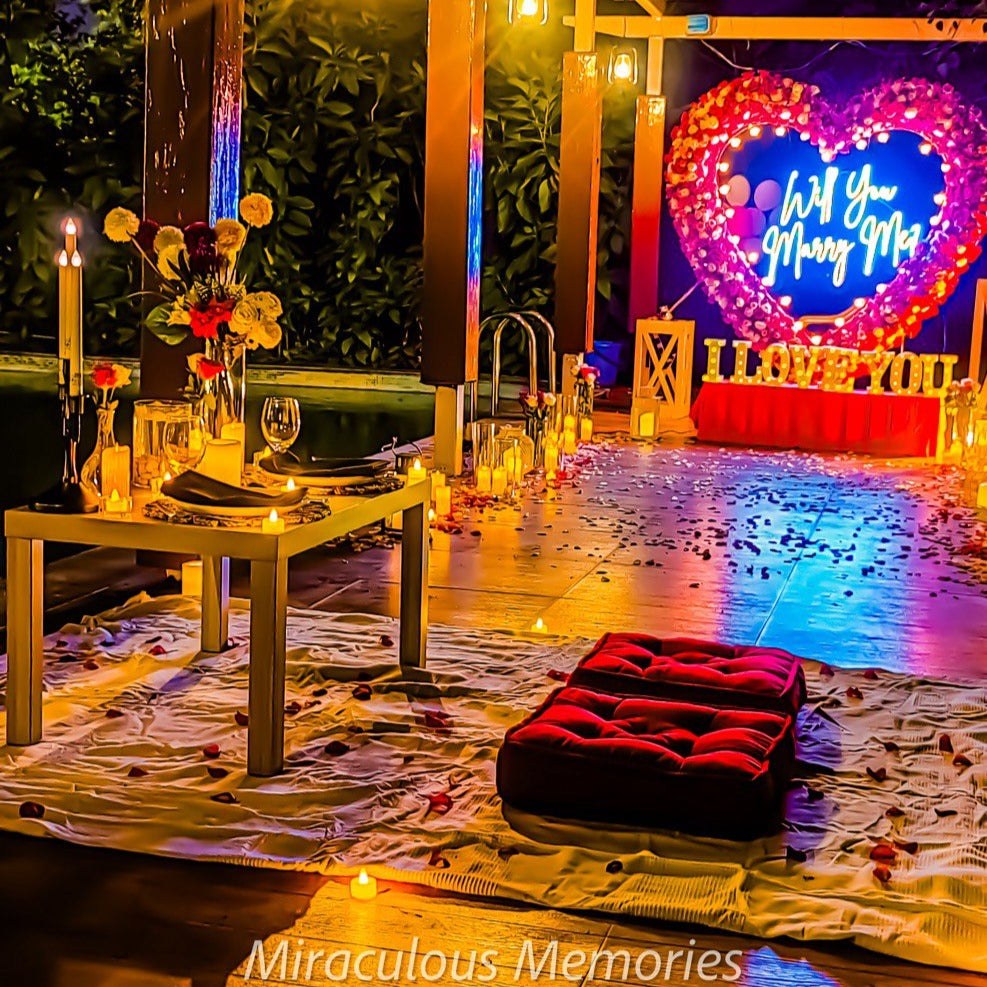 Luxury proposal setup with heart-shaped flower arrangements and candles for a romantic candle light dinner in Hyderabad.