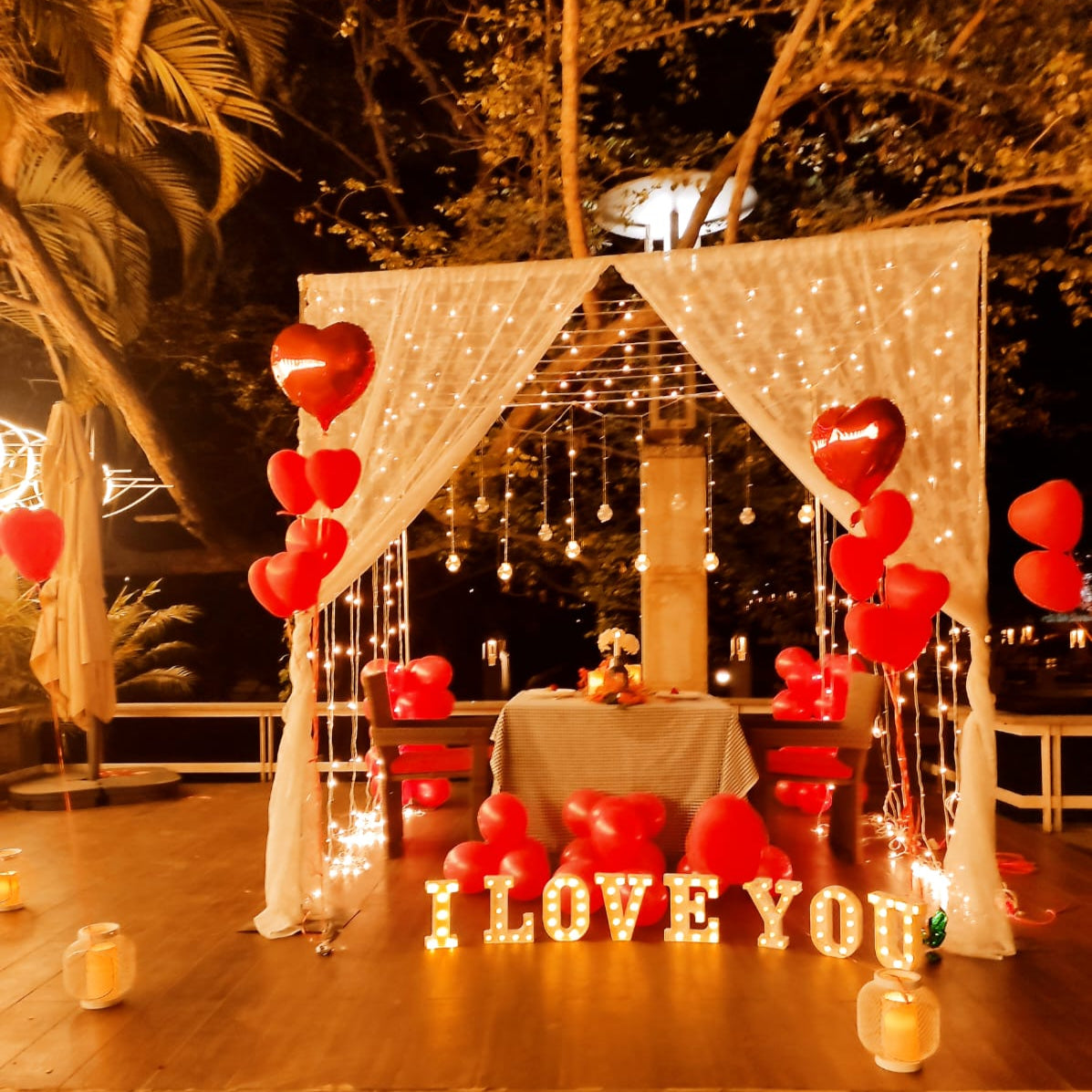Luxurious birthday celebration setup in Hyderabad with real roses, helium balloons, and LED letters.