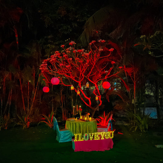 Romantic open-air candle light dinner in Hyderabad with LED lights spelling 'HAPPY BIRTHDAY' for a magical celebration.
