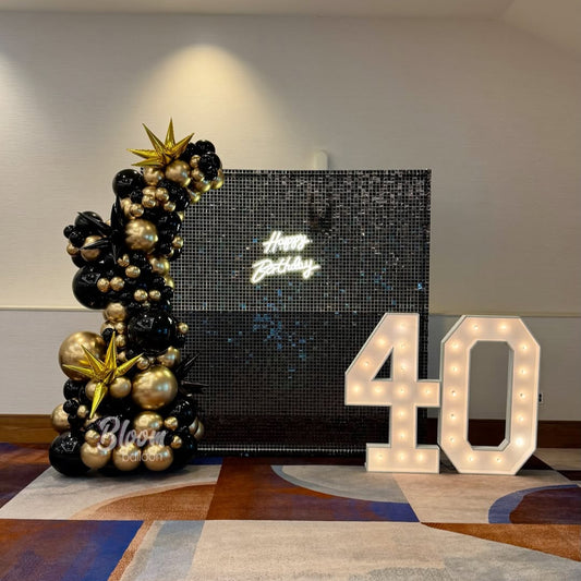 Luxury black and gold birthday decoration with balloon column and illuminated LED numbers in Hyderabad