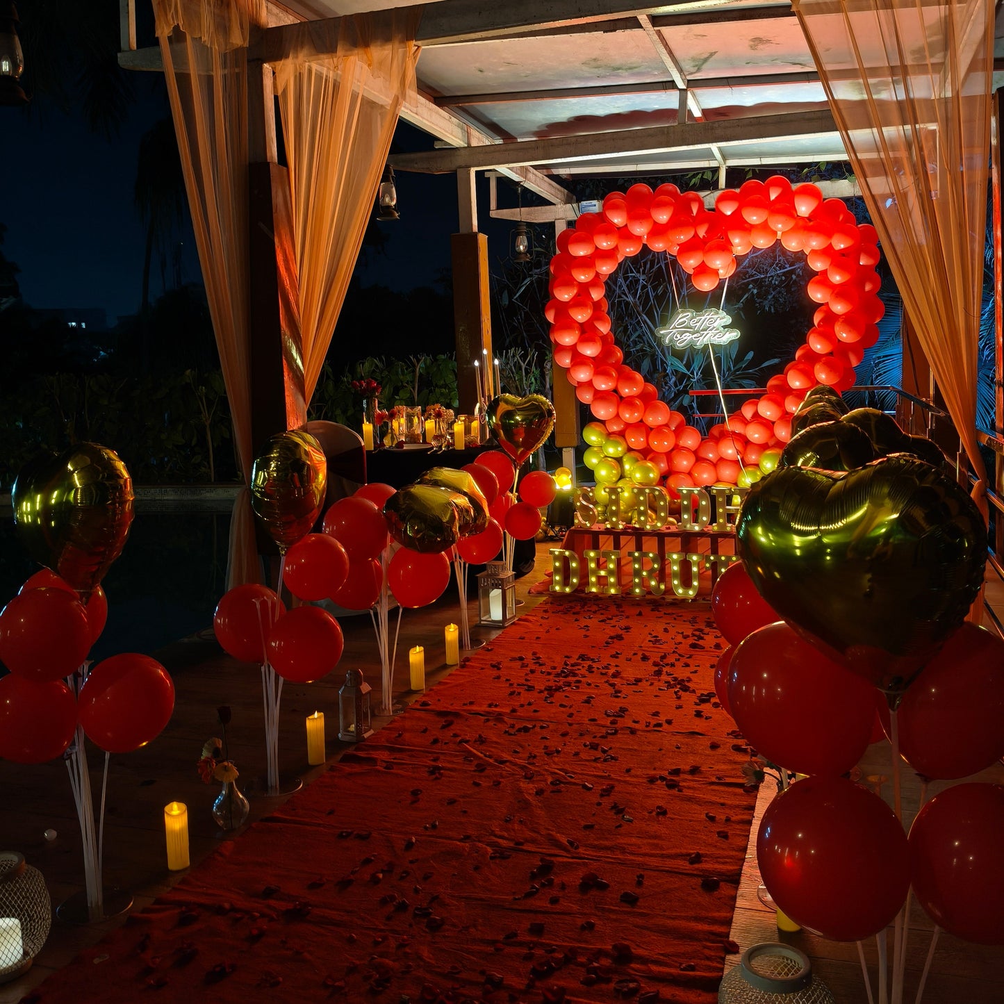 Proposal Decoration with candle light dinner at poolside. Decoration with red and gold heart-shaped balloon decoration at The Manohar Begumpet in Hyderabad
