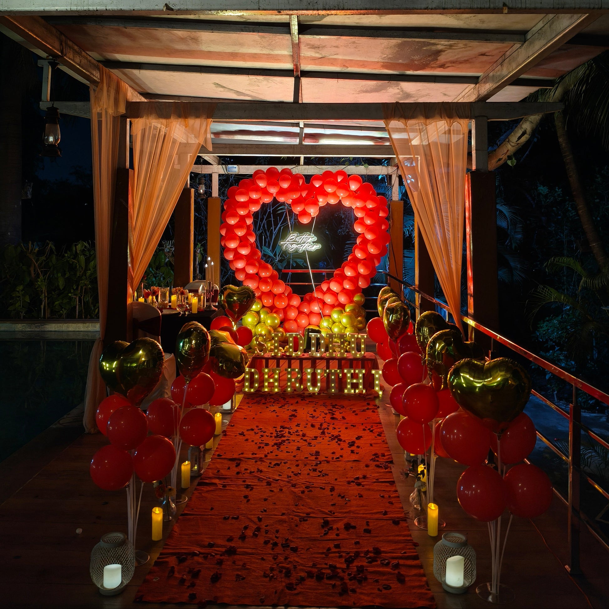 Romantic proposal decoration in red and gold theme at poolside with Candle light Dinner 