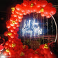 A romantic proposal setup featuring a neon sign reading "Will You Marry Me?" surrounded by vibrant red and gold balloons.