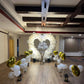 A romantic proposal setup featuring a heart-shaped arrangement of white and silver balloons, with "Will You Marry Me?" illuminated in the center.