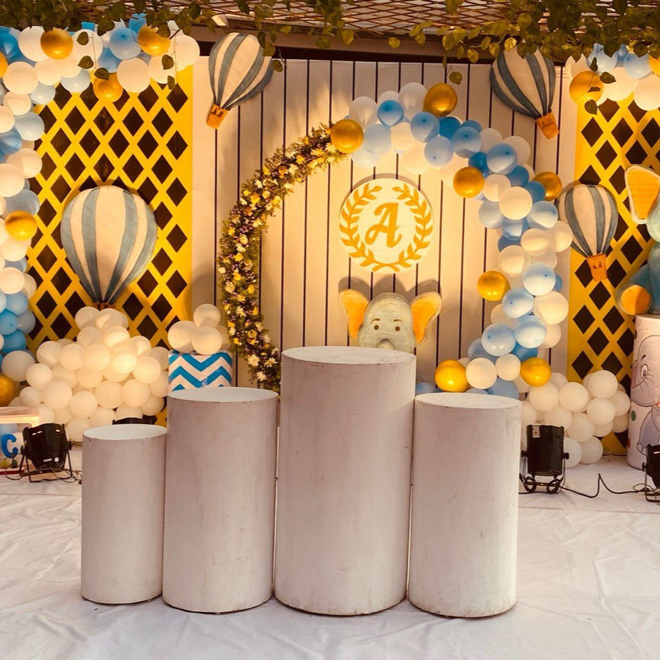 Hyderabad Baby Elephant Birthday Decoration featuring pastel balloon garland, hot air balloon backdrop, elephant cutouts, cake table setup, and festive lighting.