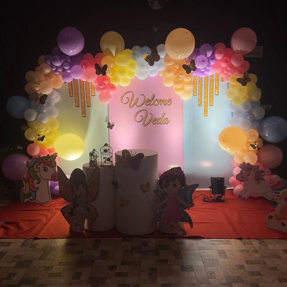 Customized fairyland unicorn pastel birthday decoration with butterfly accents, colorful balloons, and themed backdrop in Hyderabad