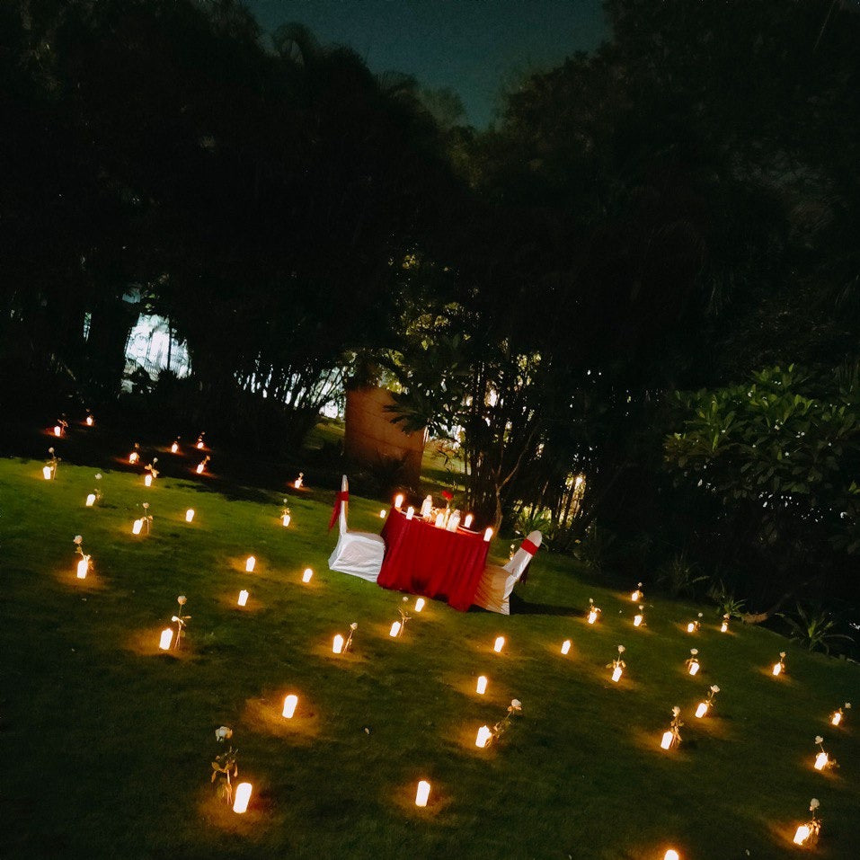 "Magical open-air proposal setup in Hyderabad with romantic candle light dinner decor by Miraculous Memories."
